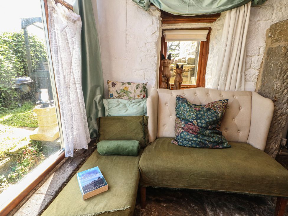 A living room with a sofa and book at Moldy Warp Barn in Haworth