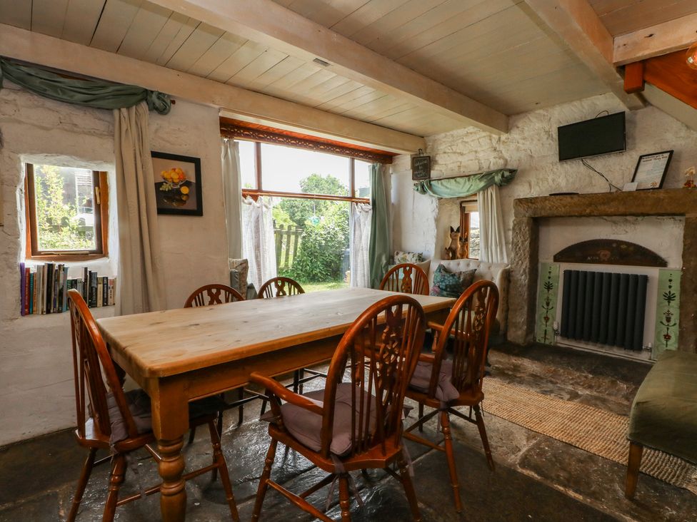 A dining room with a wooden table and chairs at Moldy Warp Barn in Haworth