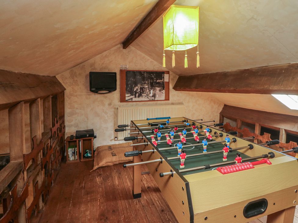A games room with a foosball table and a television at Moldy Warp Barn in Haworth