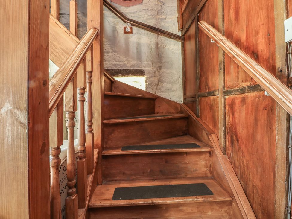 A staircase with wooden steps and railing at Moldy Warp Barn in Haworth