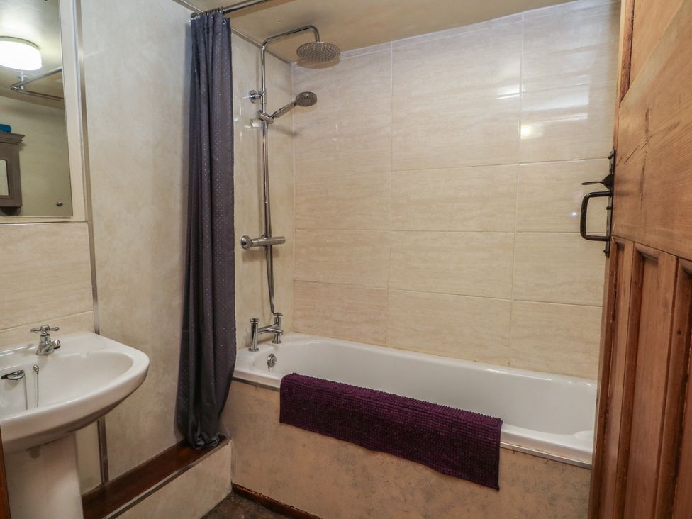 A bathroom with a bathtub, sink and shower at Moldy Warp Barn in Haworth