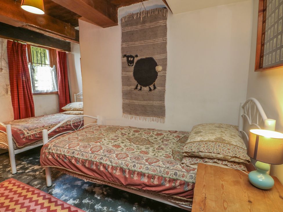 A bedroom with two beds and a lamp at Moldy Warp Barn in Haworth