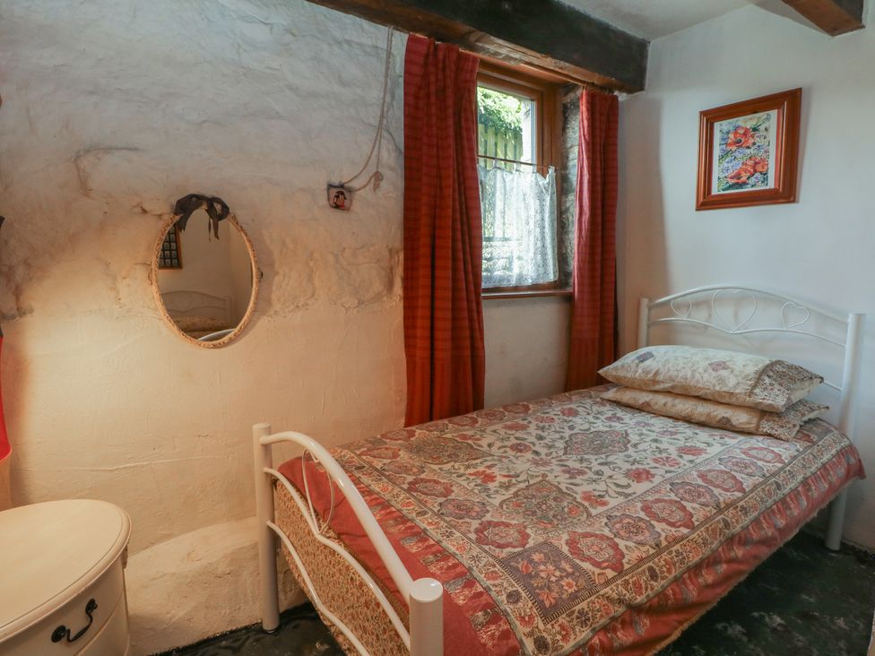 A bedroom with a bed and mirror at Moldy Warp Barn in Haworth