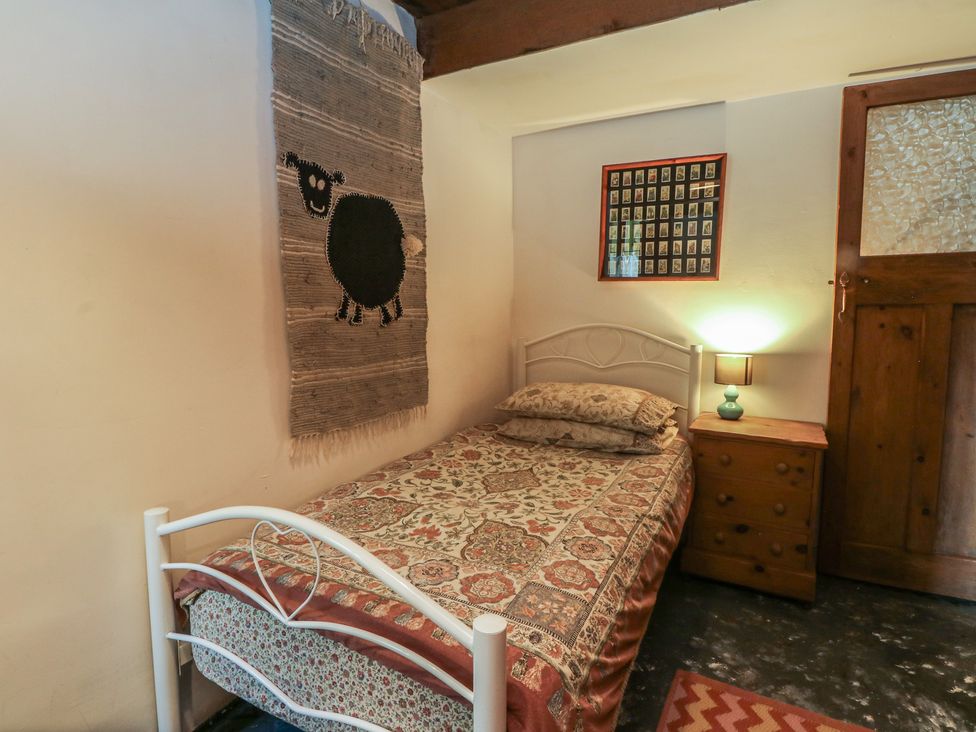 A bedroom with a bed and a wall hanging at Moldy Warp Barn in Haworth
