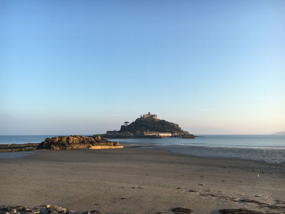 A view of an island with a castle on it from a beach at Stargazy Cottage Praa Sands