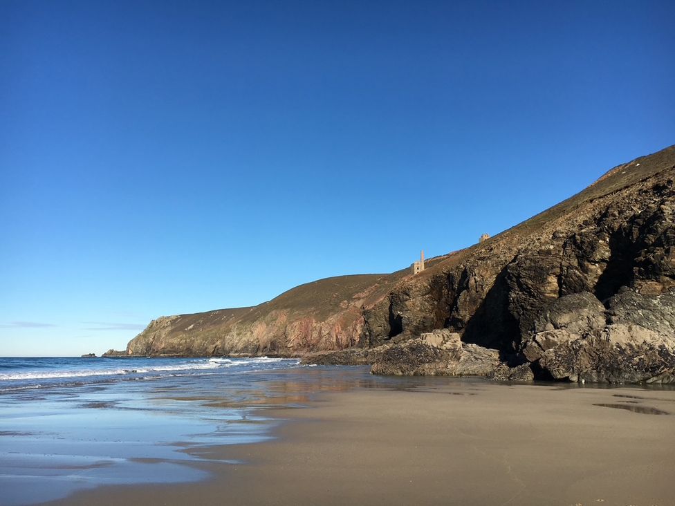 A beach with cliffs and sea at Stargazy Cottage in Praa Sands