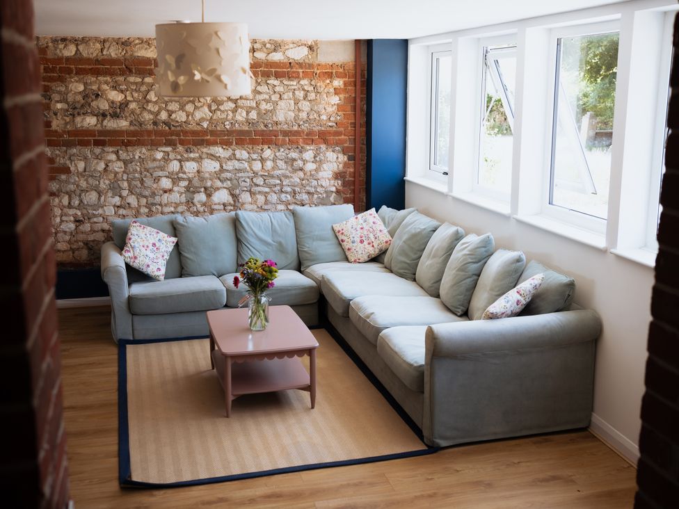 A living room with a sofa and coffee table at Newfield Farm Cottages in Pimperne near Blandford Forum