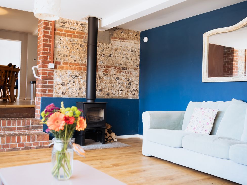 A living room with a sofa and stove at Newfield Farm Cottages Pimperne near Blandford Forum