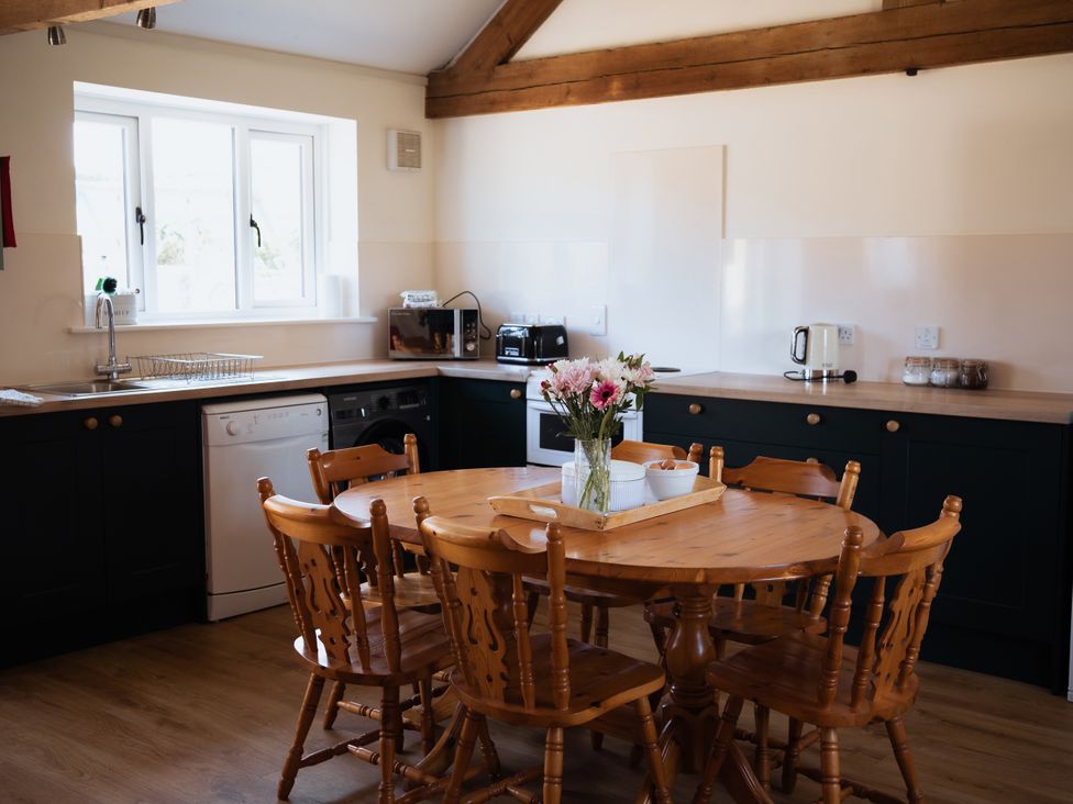 A kitchen with a table and chairs at Newfield Farm Cottages in Pimperne near Blandford Forum