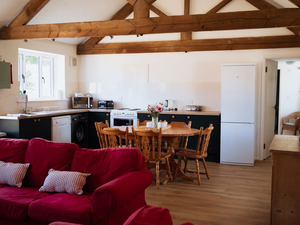 A kitchen with a dining table and appliances at Newfield Farm Cottages in Pimperne near Blandford Forum
