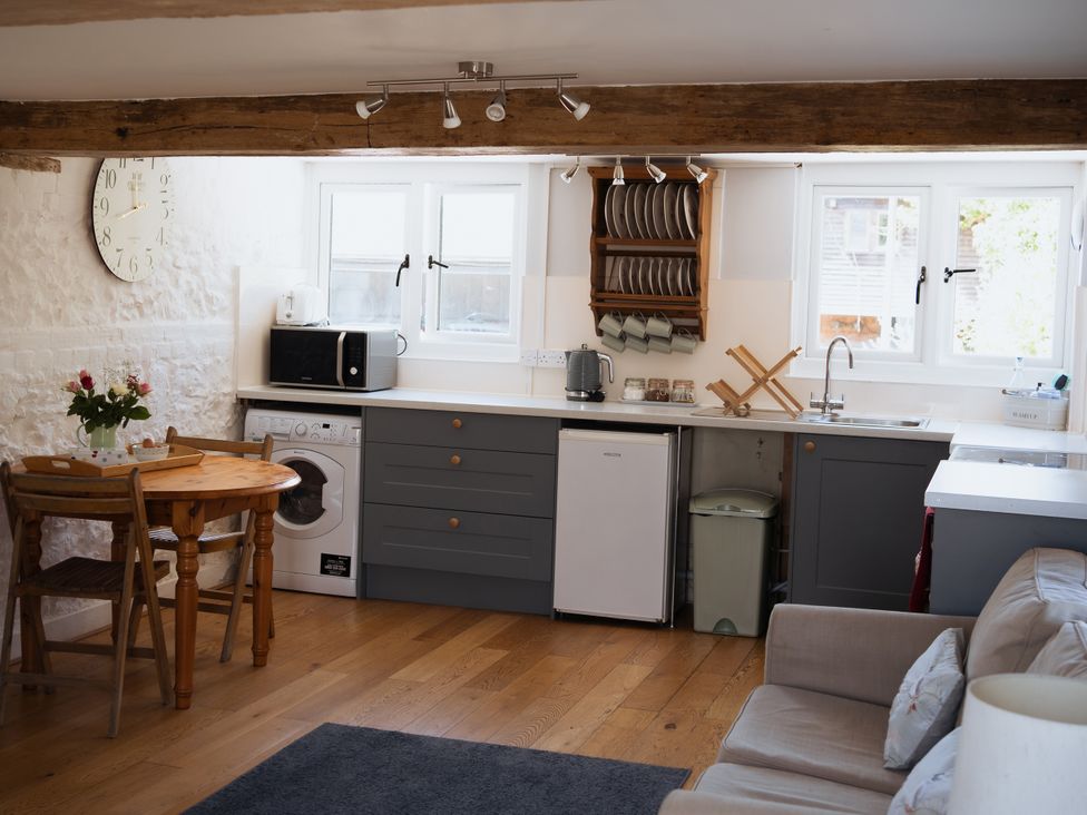 A kitchen with a dining table and appliances at Newfield Farm Cottages in Pimperne near Blandford Forum