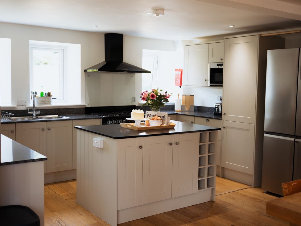 A kitchen with an island and sink at Newfield Farm Cottages in Pimperne near Blandford Forum