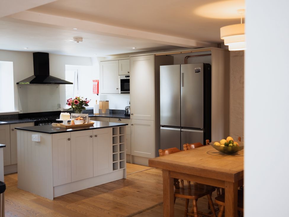 A kitchen with a dining table and refrigerator at Newfield Farm Cottages Pimperne near Blandford Forum