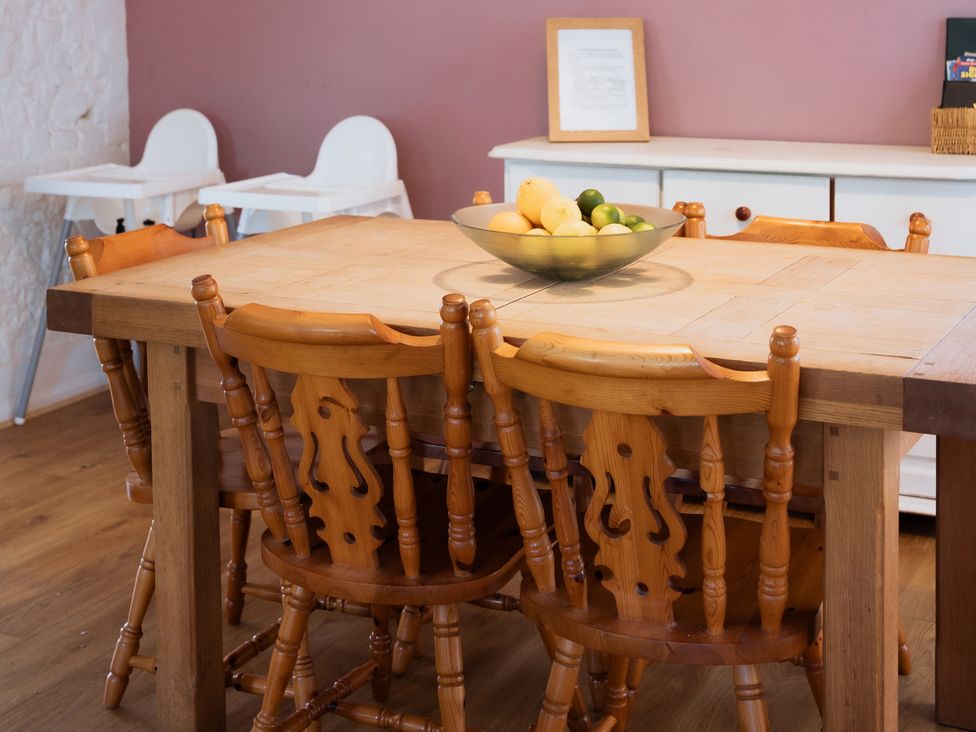 A dining room with a wooden table and fruit bowl at Newfield Farm Cottages Pimperne near Blandford Forum