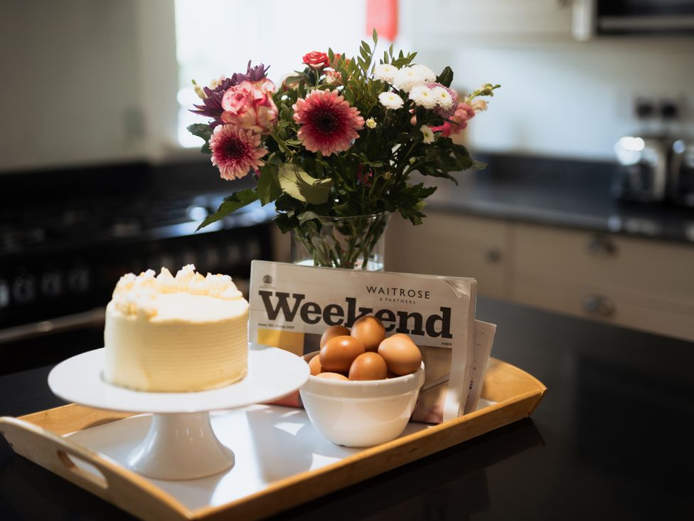 A tray with a cake, bowl of eggs, and flowers at Newfield Farm Cottages in Pimperne near Blandford Forum