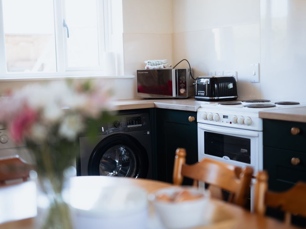 A kitchen with a washing machine and microwave at Newfield Farm Cottages Pimperne near Blandford Forum