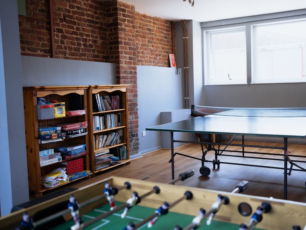A game room with a table tennis table and a bookshelf at Newfield Farm Cottages Pimperne near Blandford Forum