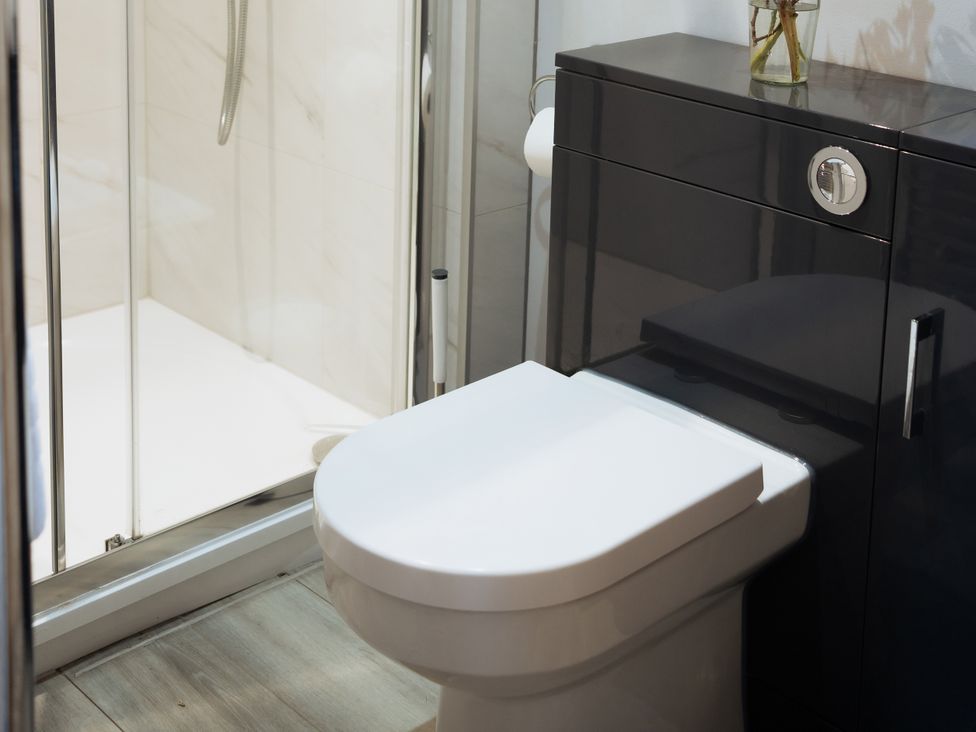 A bathroom with a toilet and shower at Newfield Farm Cottages Pimperne near Blandford Forum