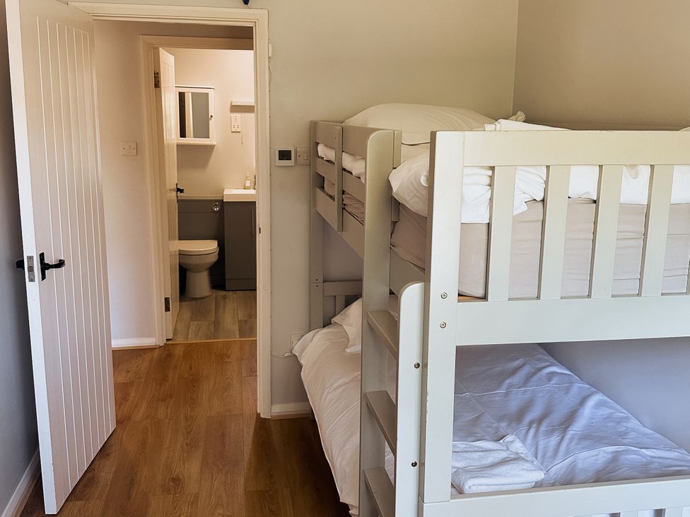 A bedroom with bunk beds and an attached bathroom at Newfield Farm Cottages Pimperne near Blandford Forum