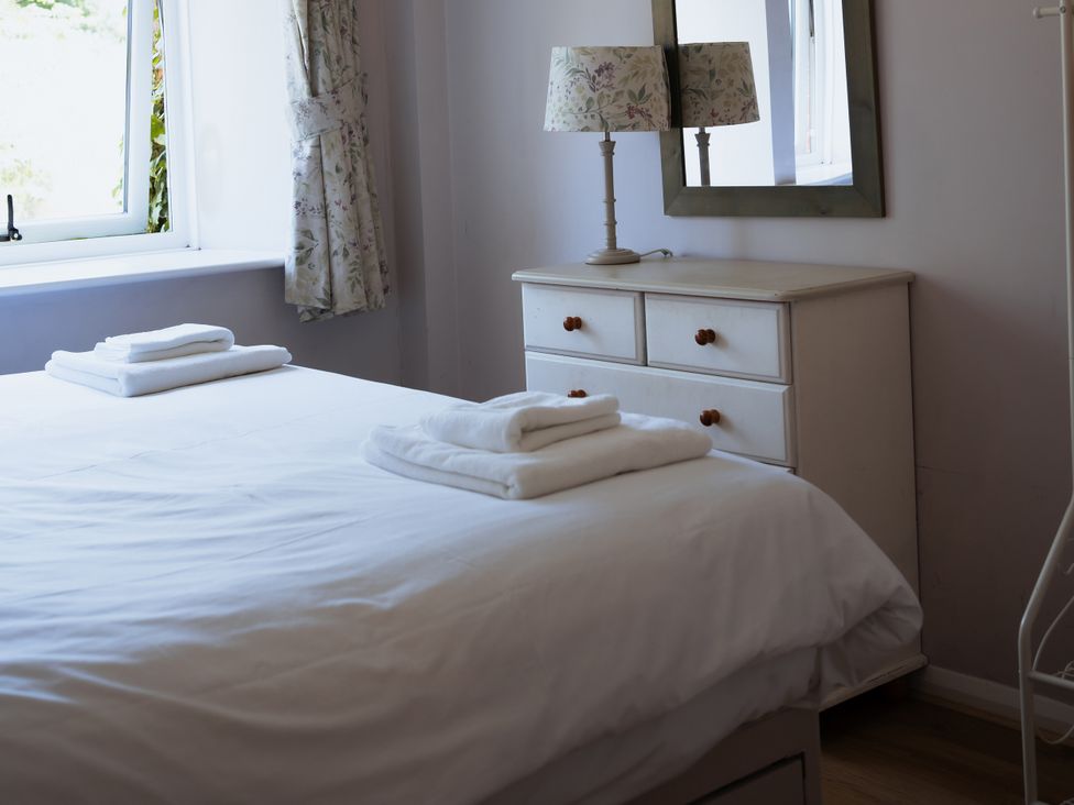 A bedroom with a bed and dresser at Newfield Farm Cottages Pimperne near Blandford Forum