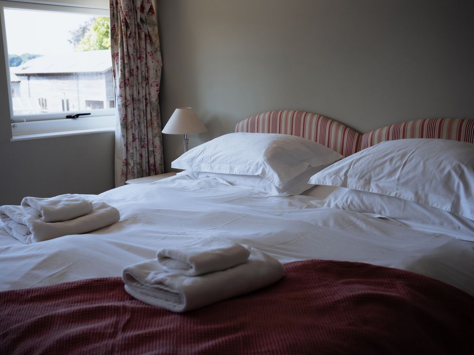 A bedroom with a bed and lamp at Newfield Farm Cottages Pimperne near Blandford Forum