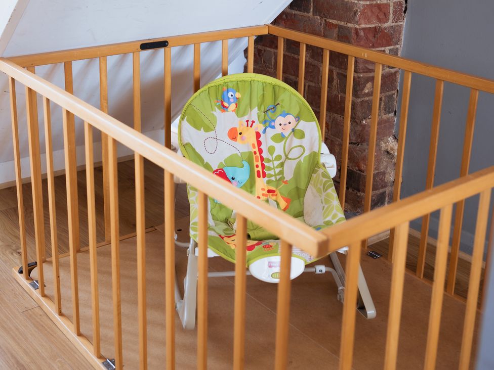 A baby gate with a rocking chair at Newfield Farm Cottages in Pimperne near Blandford Forum
