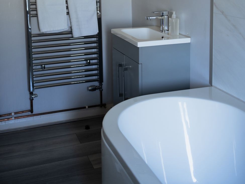 A bathroom with a bathtub and sink at Newfield Farm Cottages Pimperne near Blandford Forum