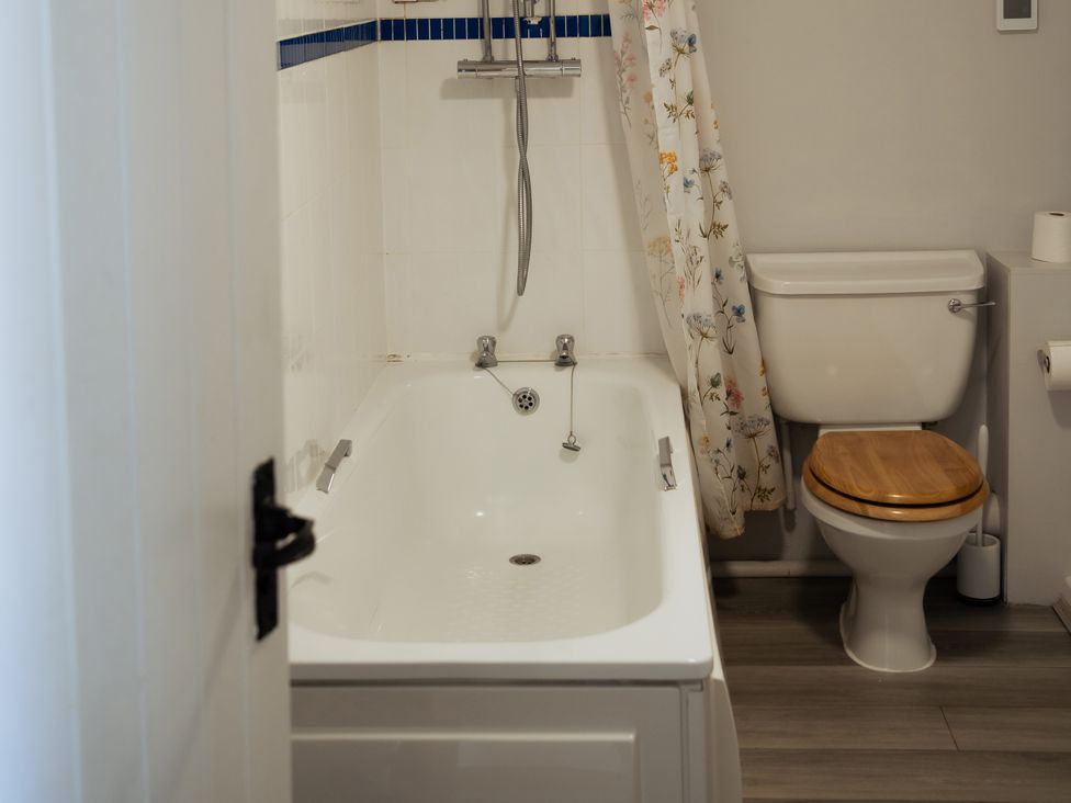 A bathroom with a bathtub and toilet at Newfield Farm Cottages in Pimperne near Blandford Forum