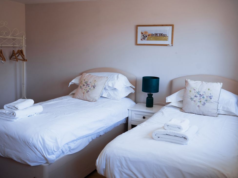 A bedroom with two beds and a lamp at Newfield Farm Cottages Pimperne near Blandford Forum