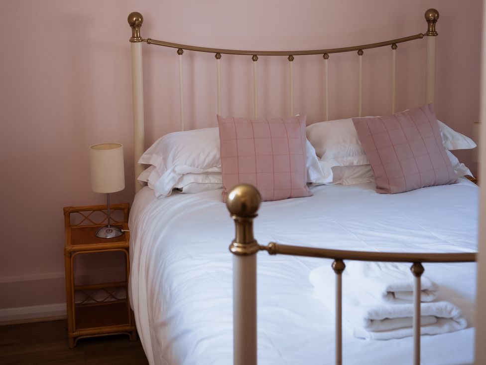 A bedroom with a bed and bedside table at Newfield Farm Cottages Pimperne near Blandford Forum