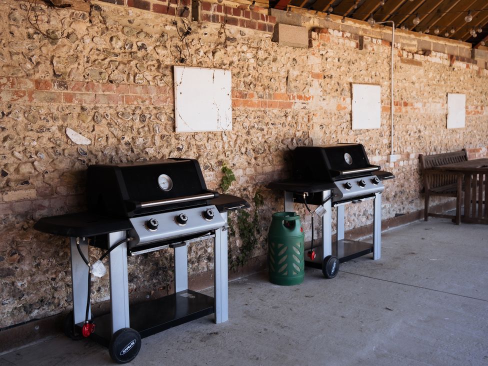 Two barbecue grills and a bench in an outdoor area at Newfield Farm Cottages Pimperne near Blandford Forum