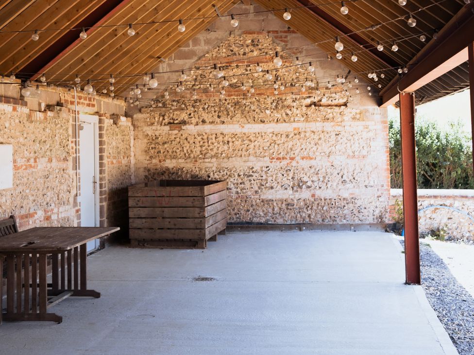 An outdoor area with a table and string lights at Newfield Farm Cottages Pimperne near Blandford Forum