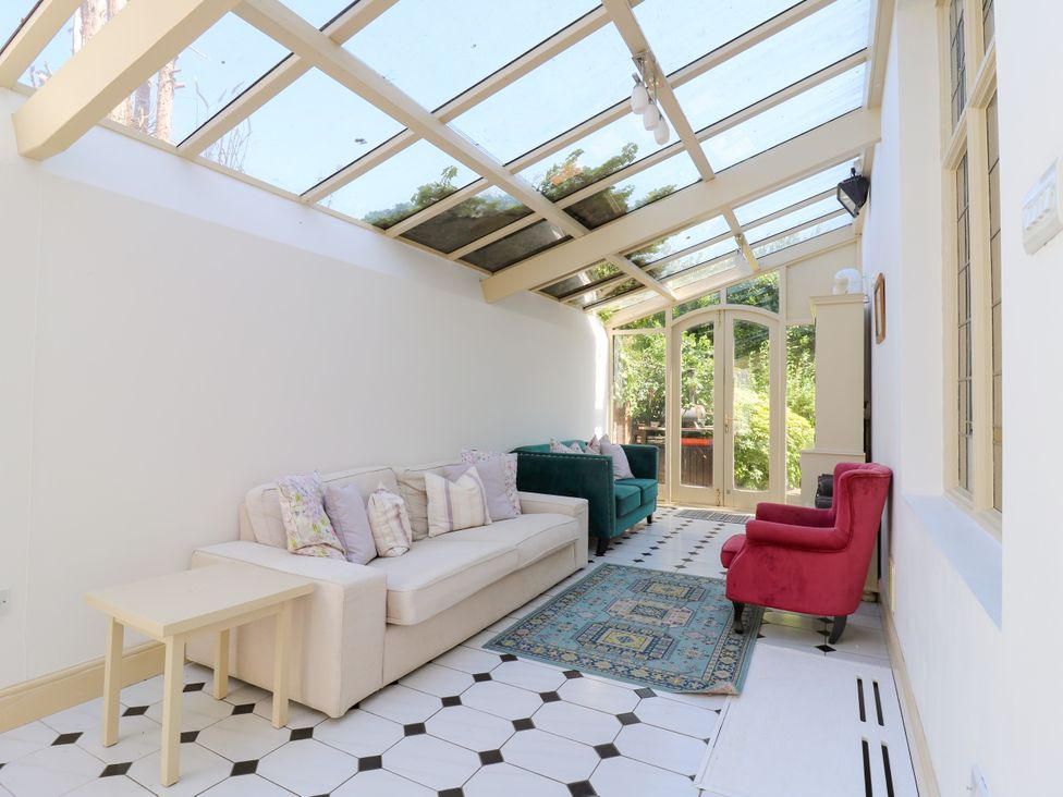 A conservatory with seating and a decorative rug at The Chestnuts in Peterborough