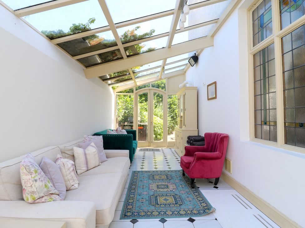 A conservatory with a sofa and rug at The Chestnuts in Peterborough