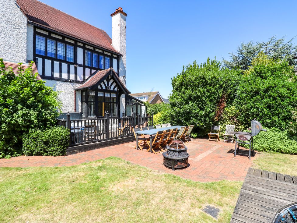 A garden with a table and chairs in front of a house at The Chestnuts in Peterborough