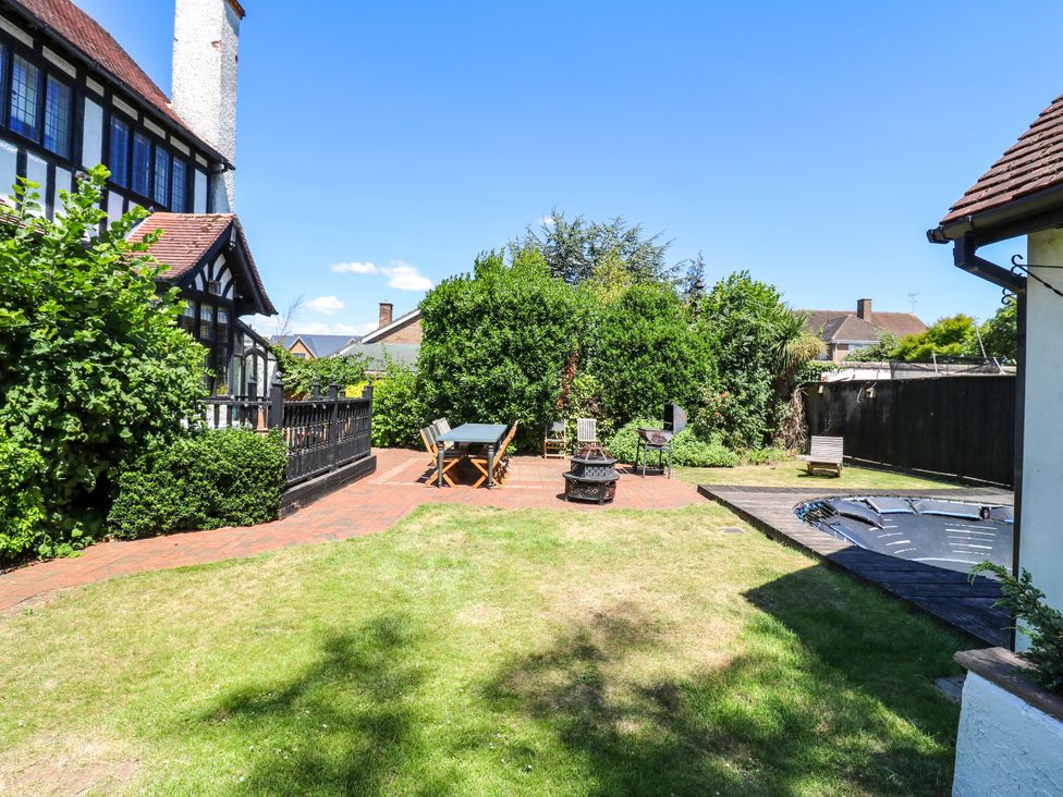 A garden with a table and chairs near a fire pit at The Chestnuts in Peterborough