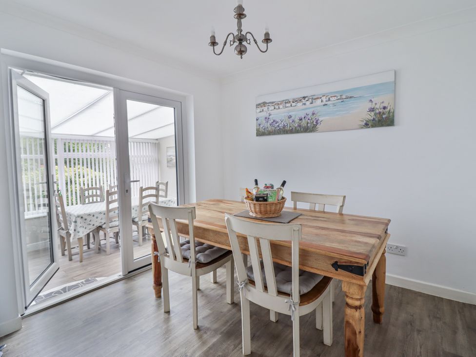 A dining room with a wooden table and chairs at 8 Glan Ysgethin in Barmouth