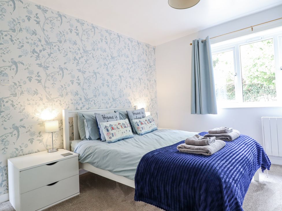 A bedroom with a bed and decorative items at 8 Glan Ysgethin in Barmouth