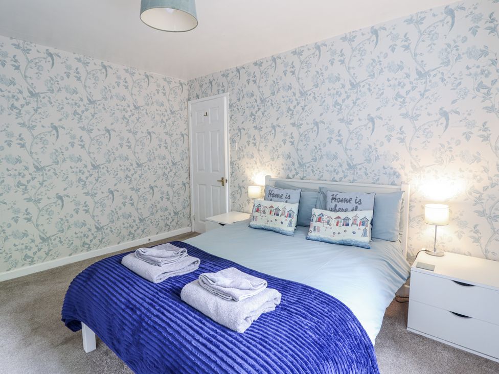 A bedroom with a bed and bedside tables at 8 Glan Ysgethin Barmouth