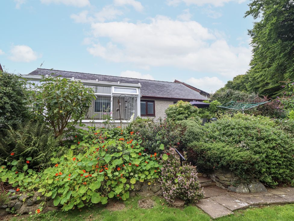 A garden with plants and a house at 8 Glan Ysgethin in Barmouth