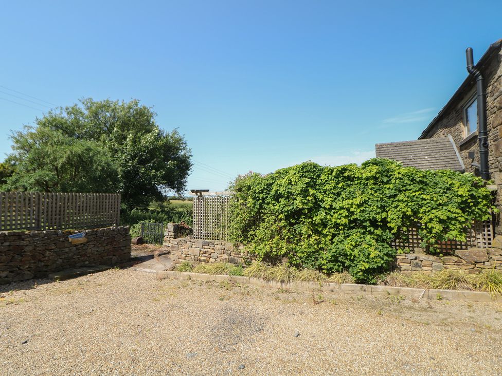 A garden with a stone wall and plants at Overlea Cottage in Hayfield