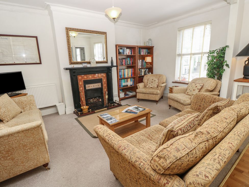A living room with a fireplace and bookshelf at Lancaster House Sandown