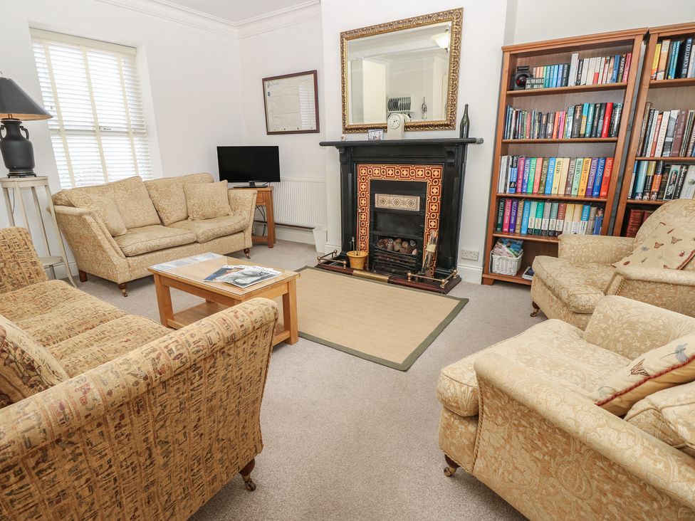 A living room with sofa and bookshelf at Lancaster House Sandown
