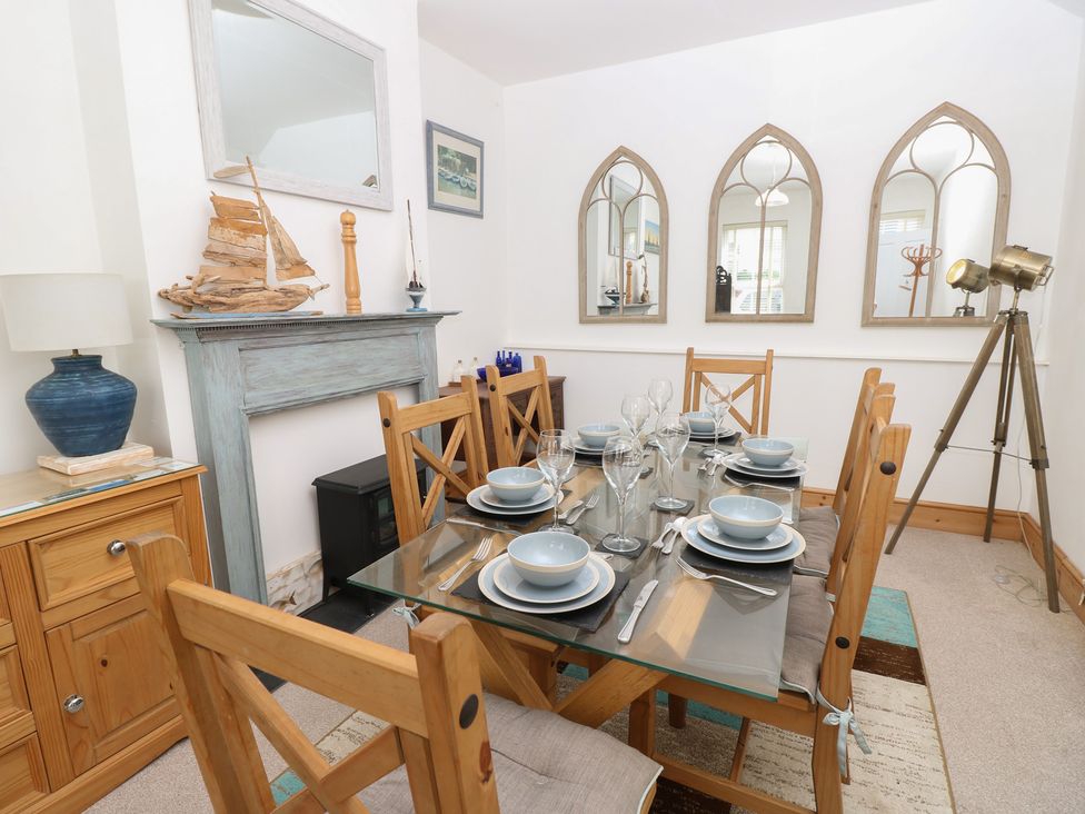 A dining room with a glass table and wooden chairs at Lancaster House in Sandown
