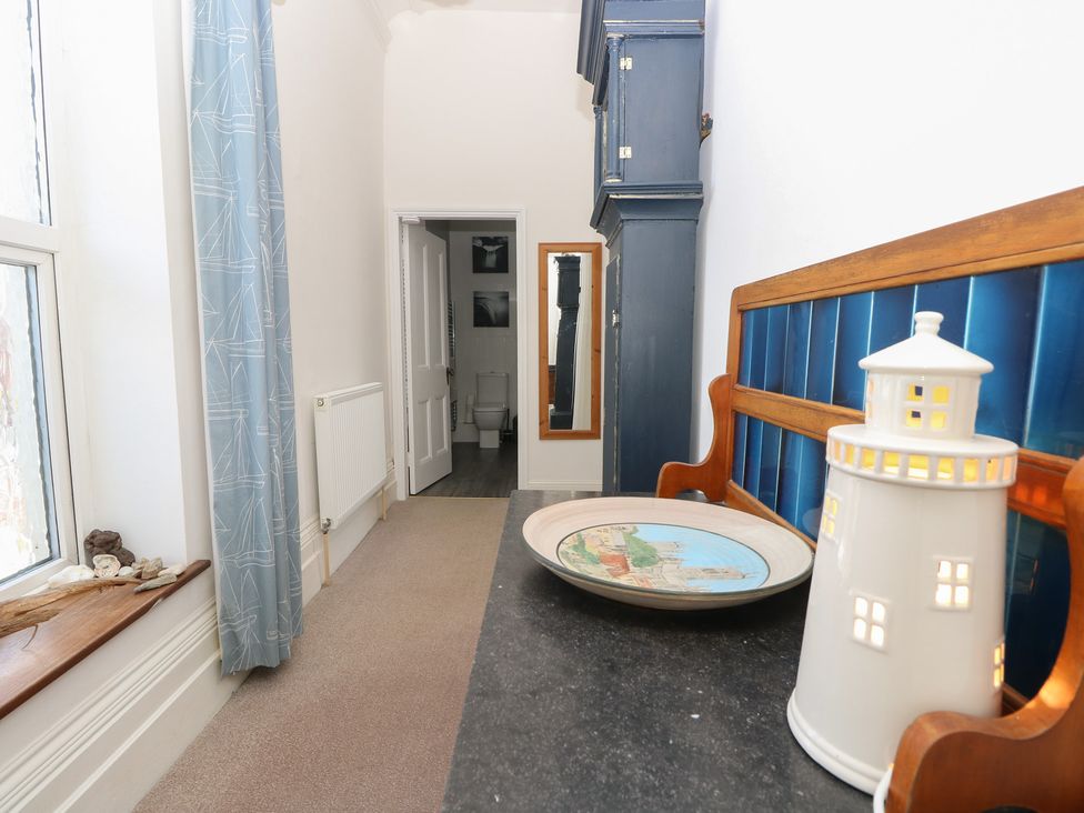 A hallway with a bench and mirror at Lancaster House in Sandown