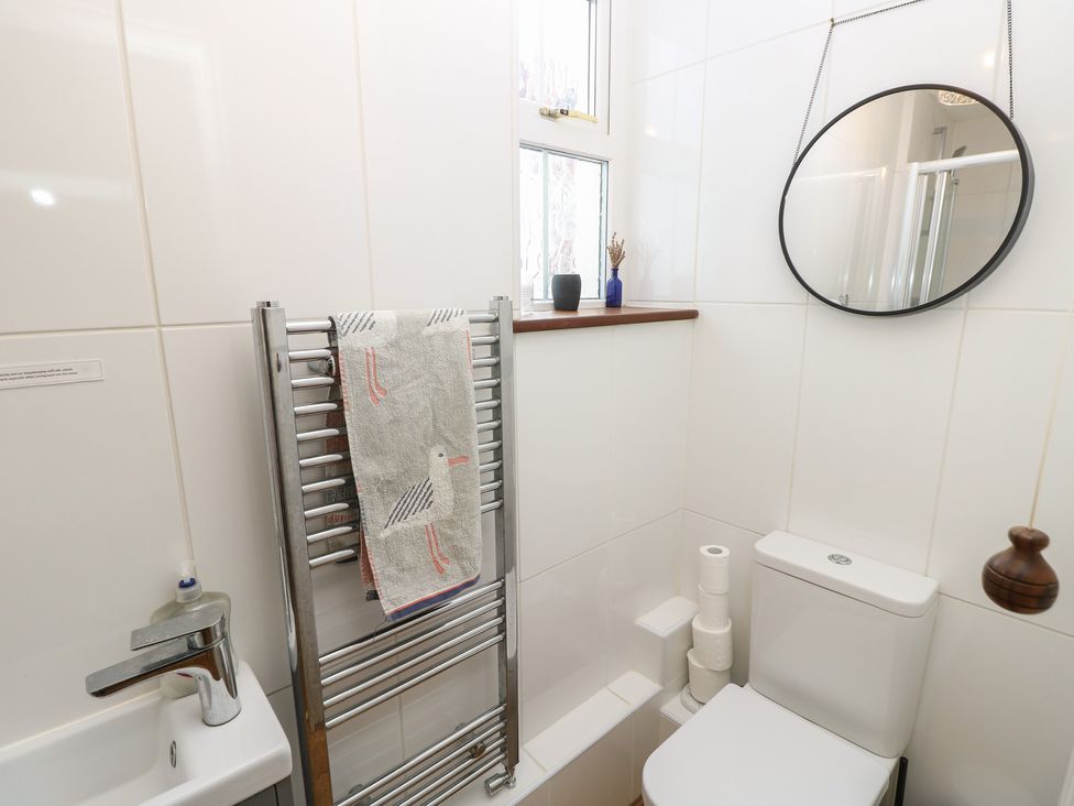 A bathroom with a toilet, sink, and towel rail at Lancaster House in Sandown