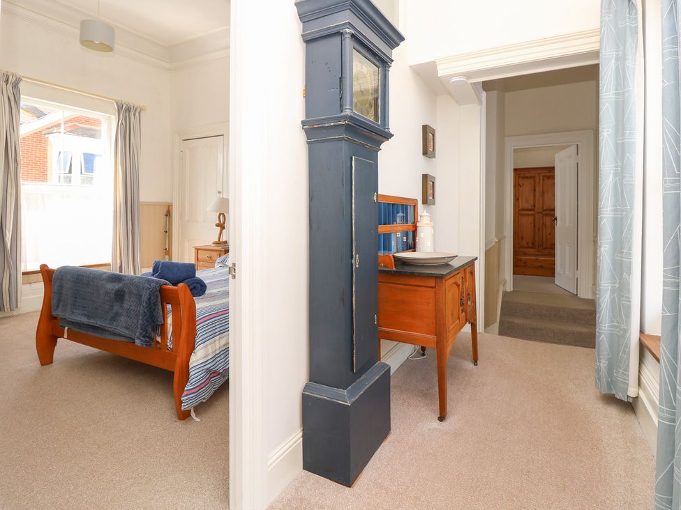 A bedroom with a bed and a clock at Lancaster House in Sandown