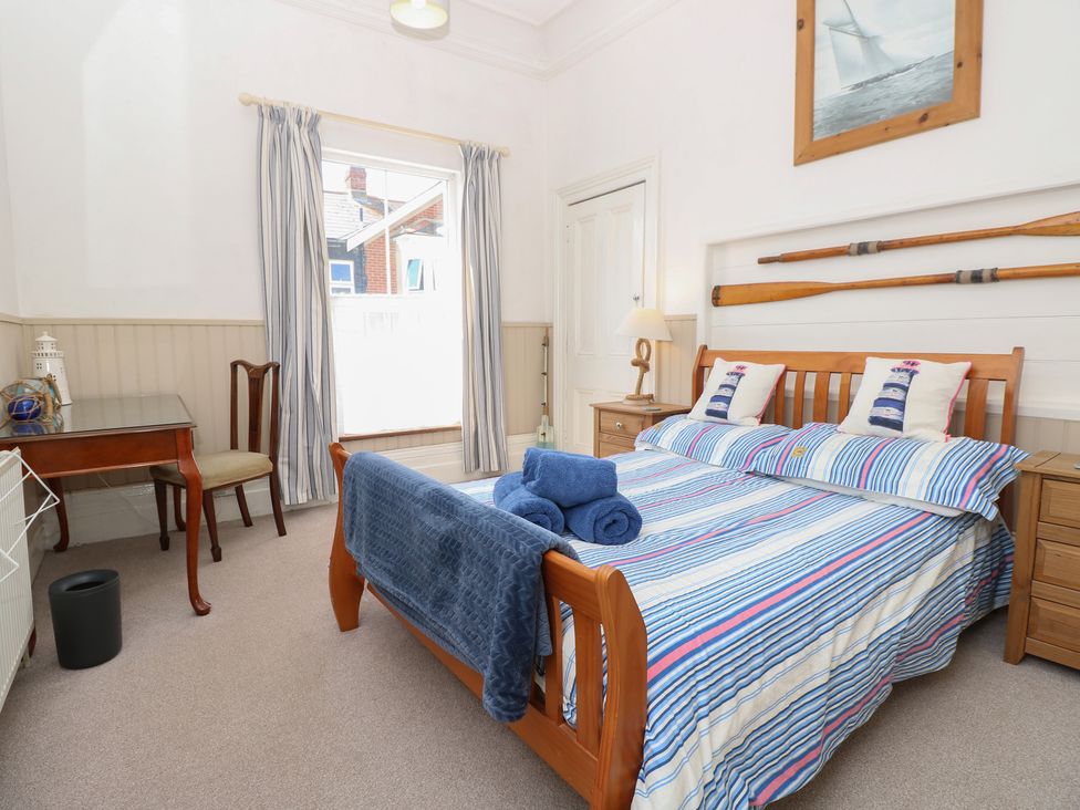 A bedroom with a bed and desk at Lancaster House in Sandown