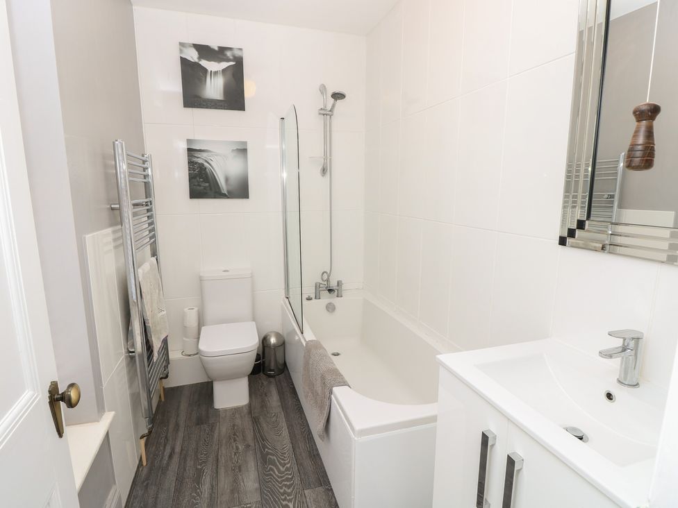 A bathroom with a bathtub and sink at Lancaster House in Sandown