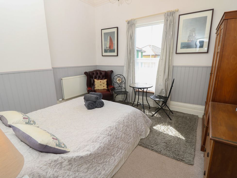 A bedroom with a bed and seating area at Lancaster House Sandown